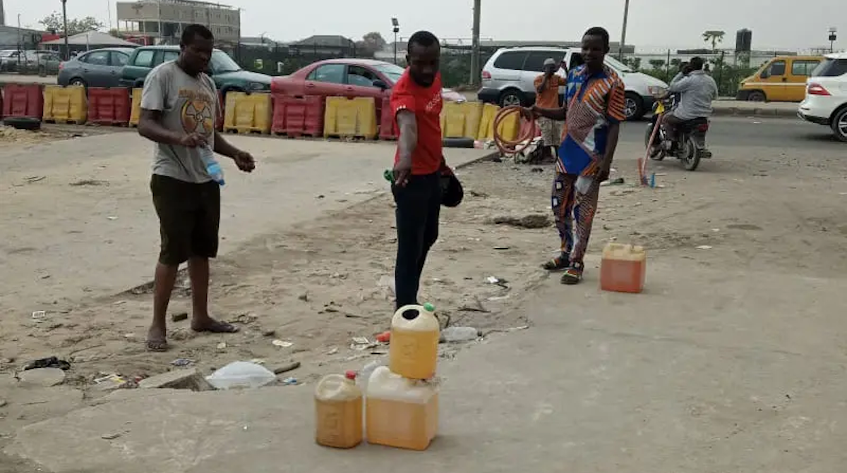 African men with gasoline in plastic jugs
